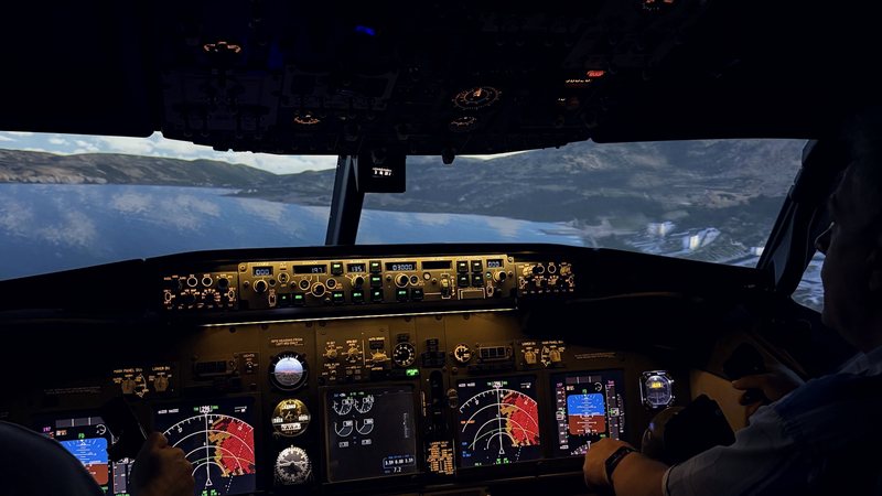 Штурвал и приборная панель авиатренажёра Boeing 737 NG, впереди горный рельеф