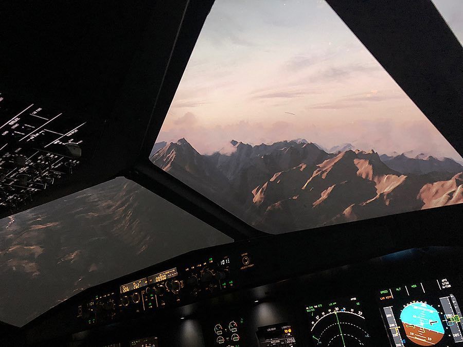Горный хребет на закате за остеклением кабины Airbus A320