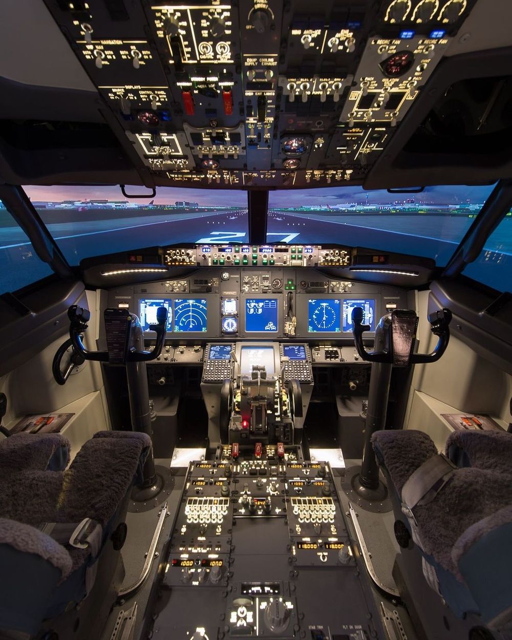 Кабина Boeing 737 на полосе 27 в сумерках: штурвалы, приборы и огни аэропорта